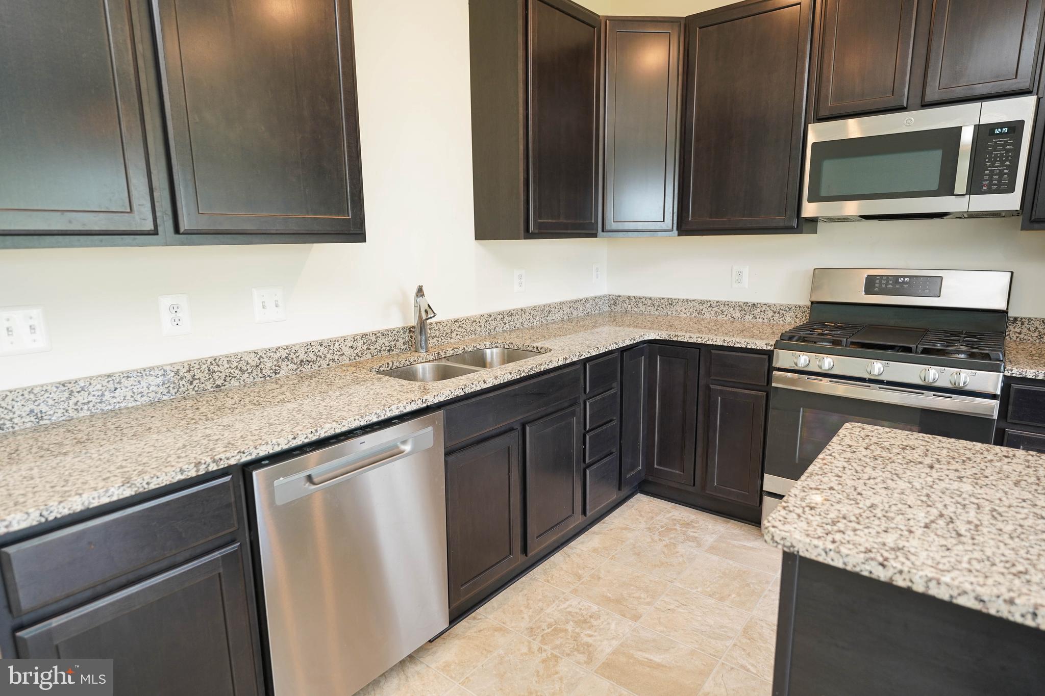 322 Appleby School Road Cambridge, MD 21613 - Photo 32 of 58 a kitchen with stainless steel appliances granite countertop a sink stove and microwave