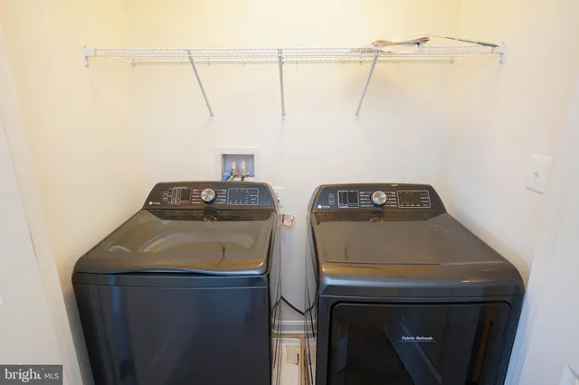 a white toilet sitting next to a white wall