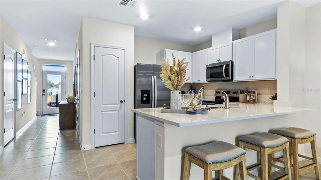 31199 Midnight Sun Way Wesley Chapel, FL 33545 - Photo 7 of 22 a kitchen with stainless steel appliances a refrigerator stove microwave and cabinets