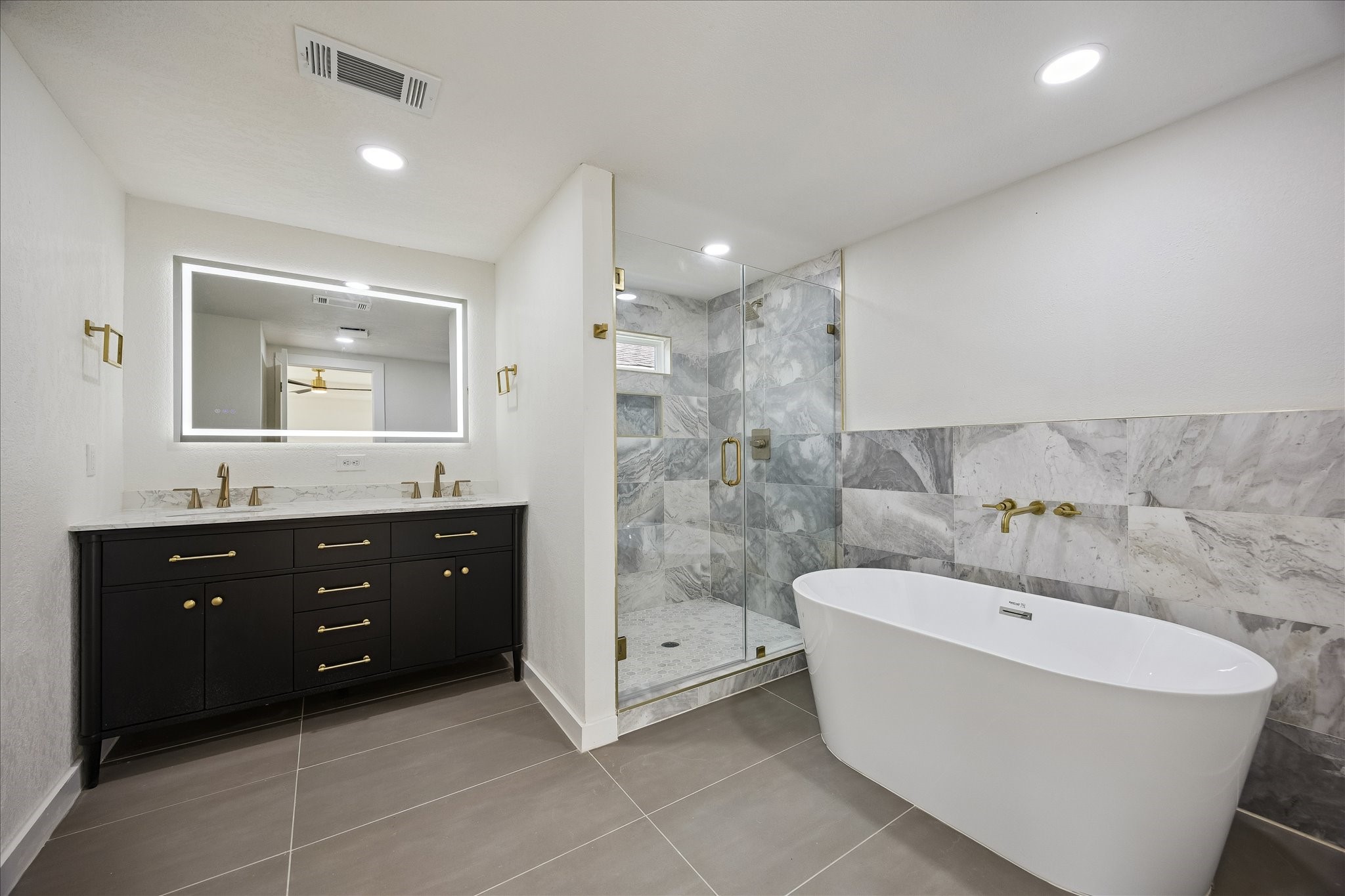 1630 Tabor Street Houston, TX 77009 - Photo 16 of 25 A spa inspired bathroom with a large soaking tub and dual sinks.