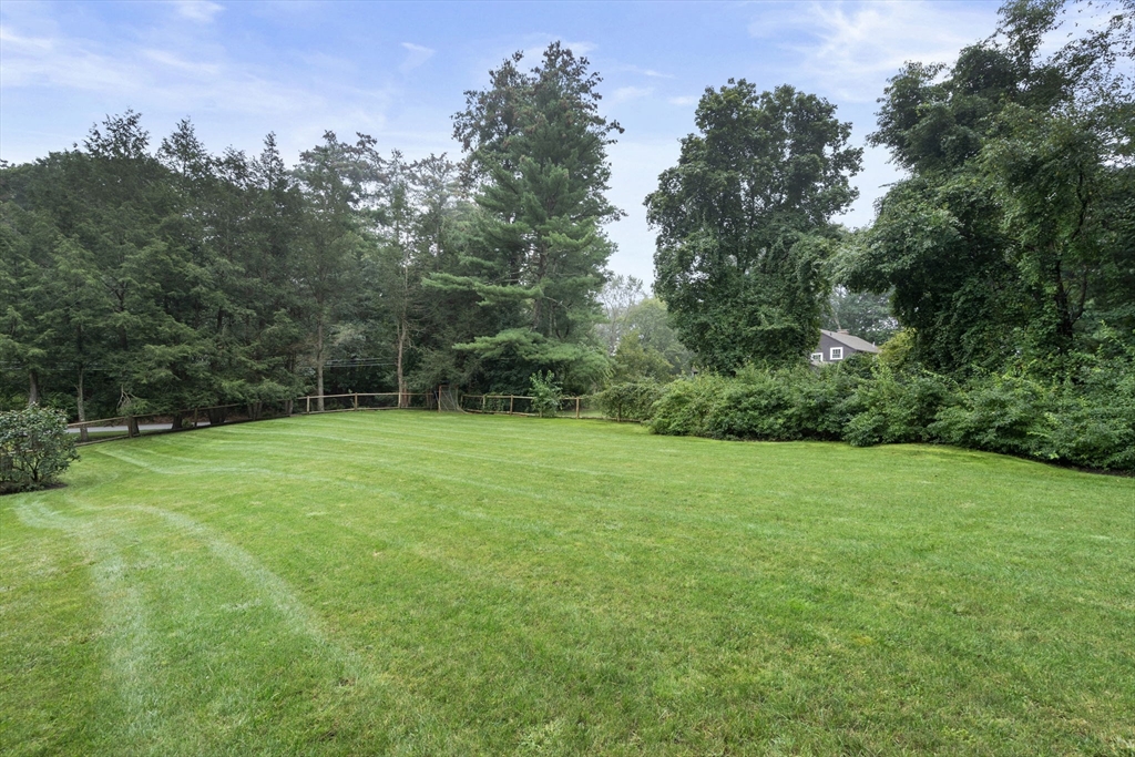 1 Sedgemeadow Road Wayland, MA 01778 - Photo 42 of 42 a view of a grassy field with trees in the background