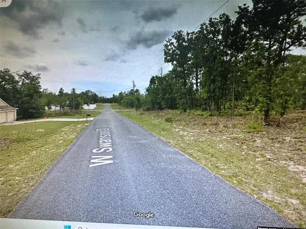 a view of a street with a yard
