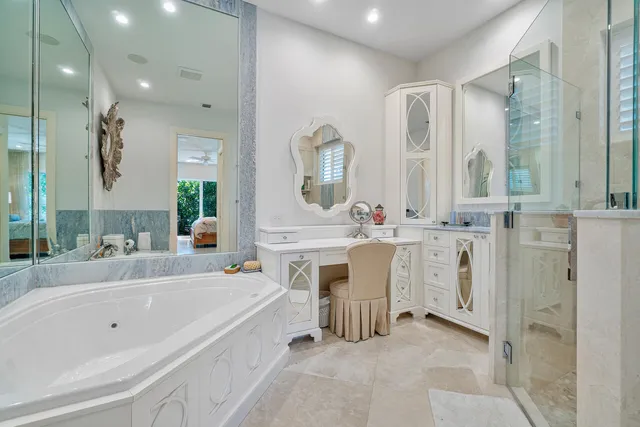 a bathroom with a tub a sink a mirror and a shower