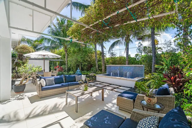 a living room with patio furniture and potted plants