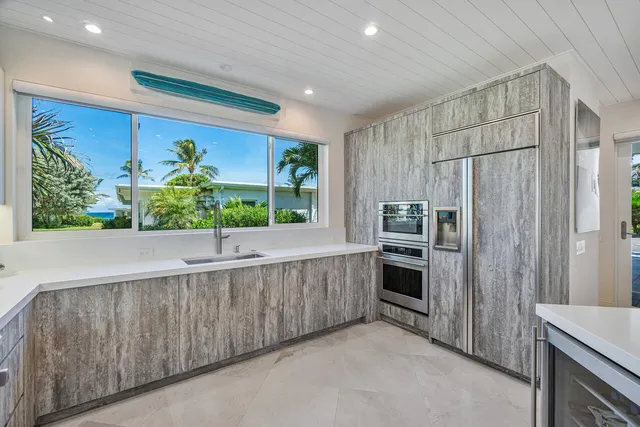 a kitchen with stainless steel appliances kitchen island granite countertop a refrigerator and a stove