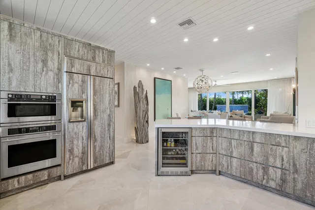 a kitchen with kitchen island a stove a refrigerator and a sink