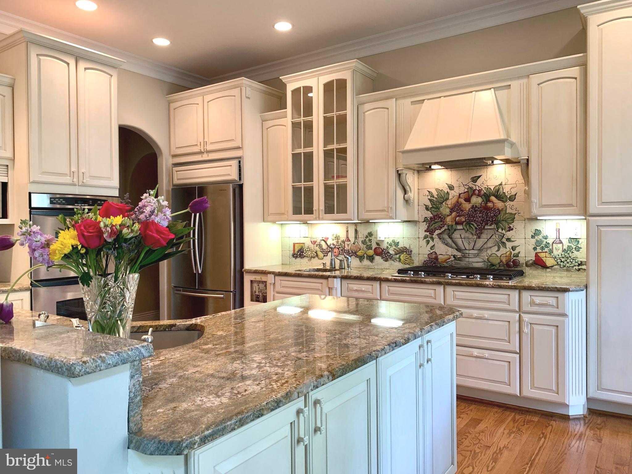 3809 Jones Bridge Road Chevy Chase, MD 20815 - Photo 24 of 70 a kitchen with stainless steel appliances granite countertop a sink and wooden cabinets