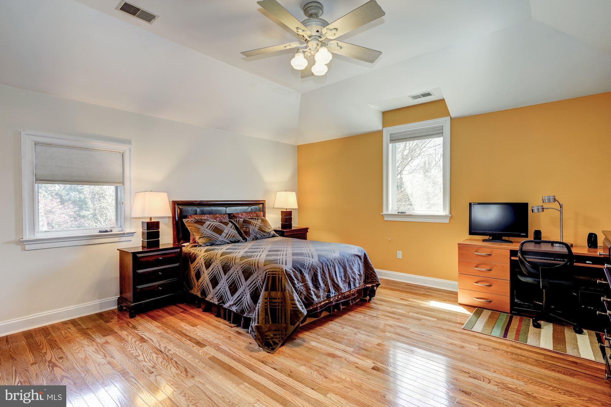 3809 Jones Bridge Road Chevy Chase, MD 20815 - Photo 44 of 70 a bedroom with a bed and a flat screen tv with wooden floor
