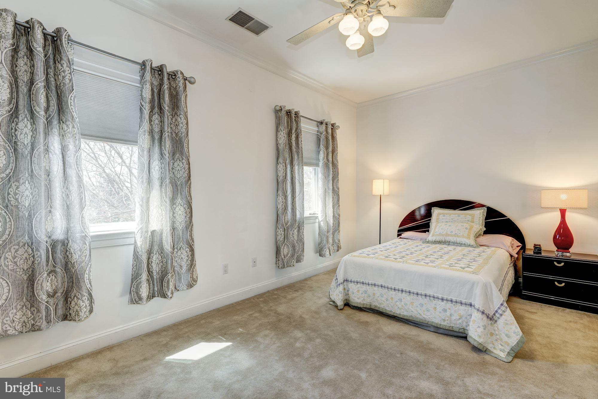 3809 Jones Bridge Road Chevy Chase, MD 20815 - Photo 47 of 70 a spacious bedroom with a bed and a chandelier