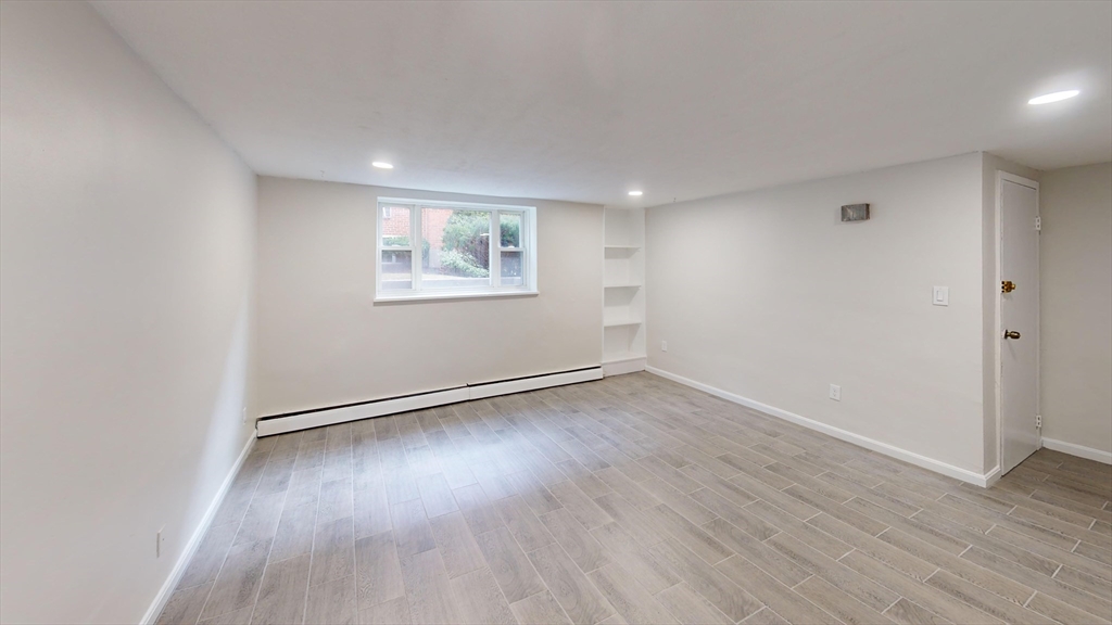 51 Colborne Road, Unit B2 Boston, MA 02135 - Photo 5 of 7 an empty room with wooden floor and windows