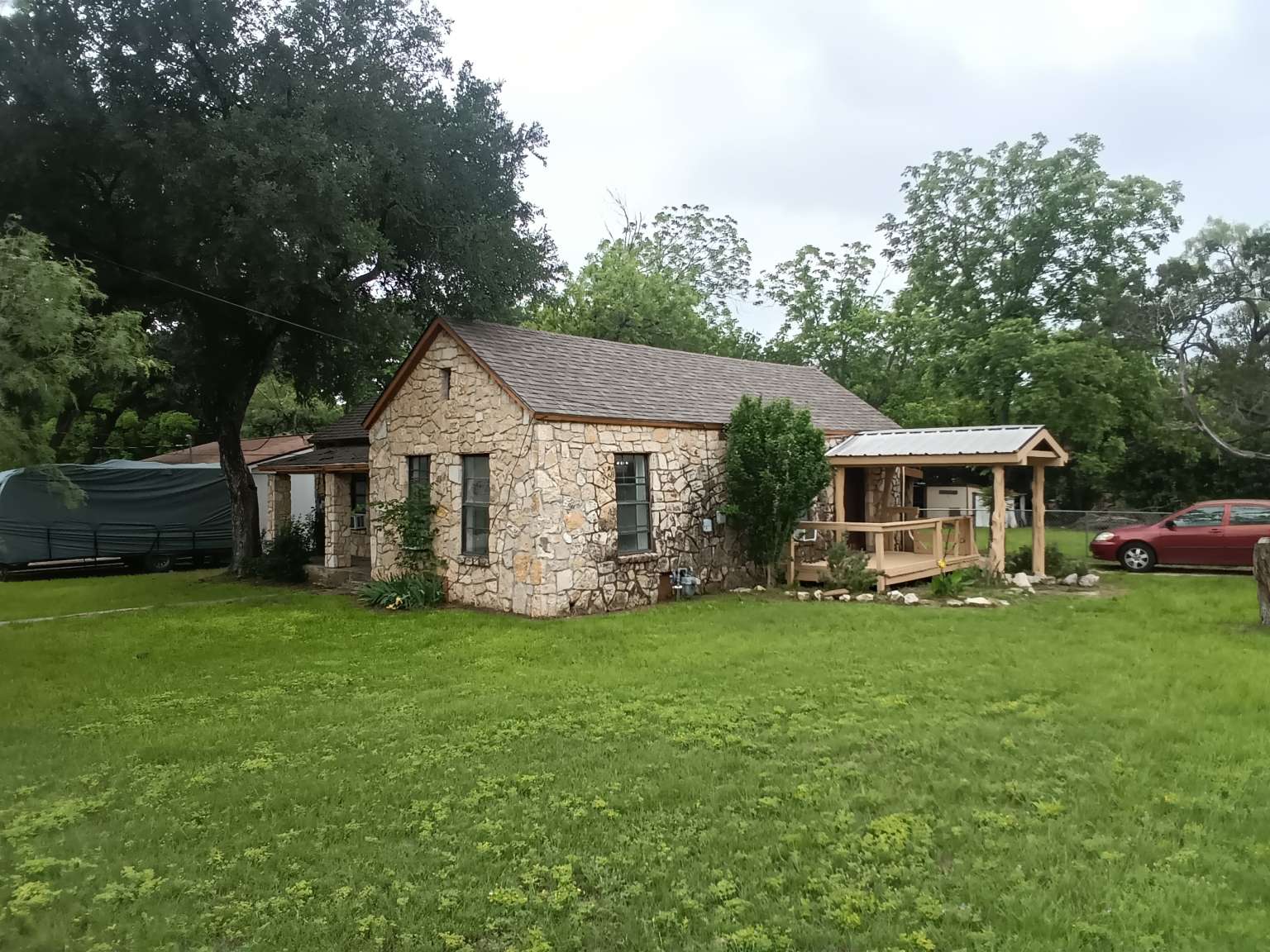 a front view of a house with a garden and trees