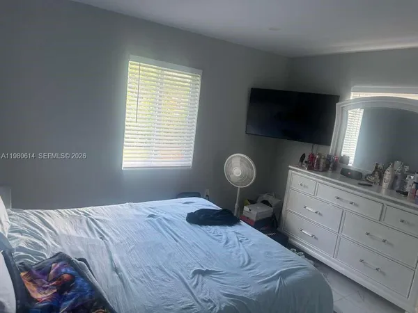 a bedroom with a bed and a flat screen tv