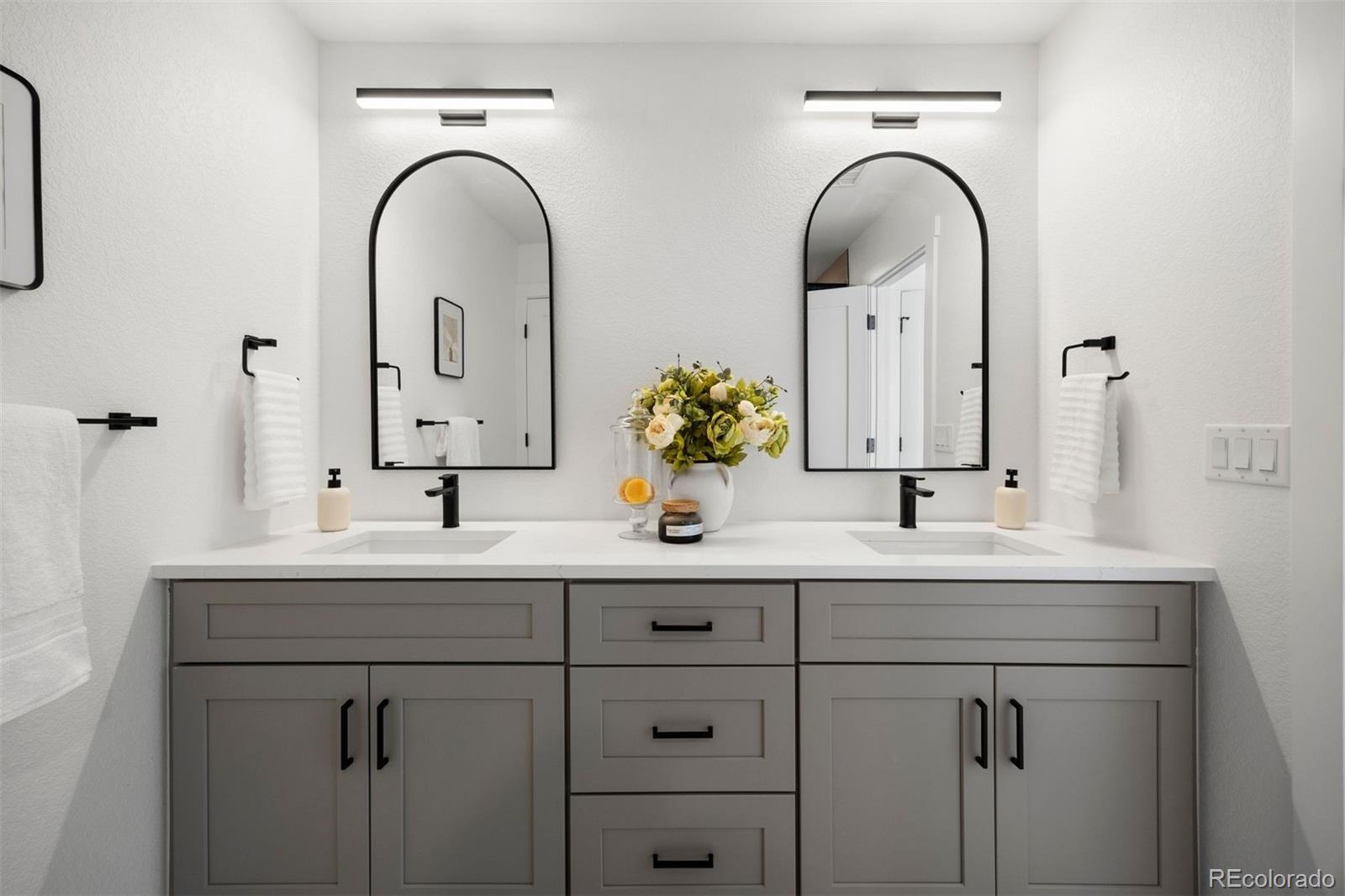 4026 Upham Street Wheat Ridge, CO 80033 - Photo 29 of 50 a bathroom with a double vanity sink and a mirror