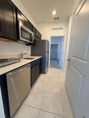 a kitchen with stainless steel appliances granite countertop a refrigerator and a stove top oven