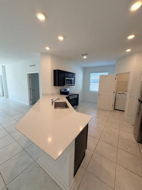 352 Kayden Cove Lake Wales, FL 33859 - Photo 18 of 32 a large white kitchen with a sink a counter top space and stainless steel appliances