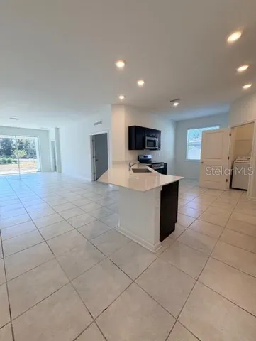 a large kitchen with kitchen island granite countertop a stove a sink a microwave and a refrigerator