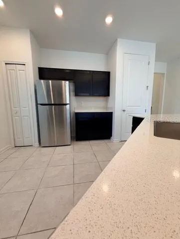 a kitchen with a refrigerator and a stove top oven