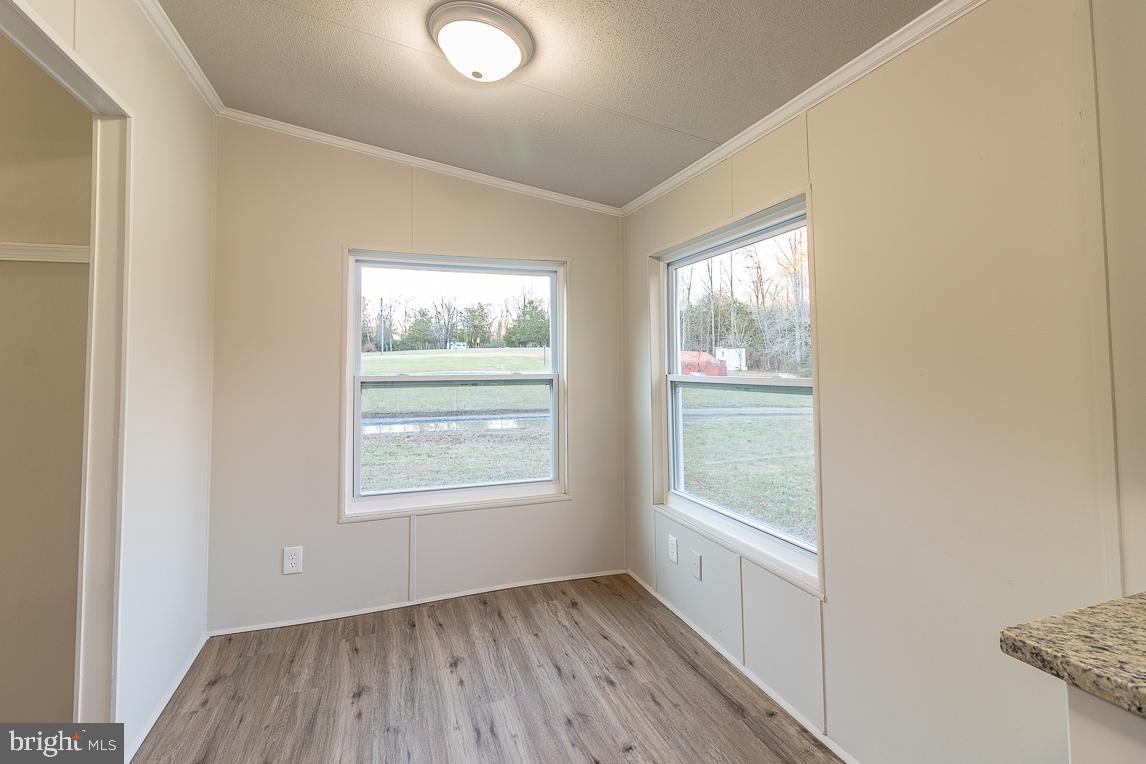 11901 Belfonte Road Bumpass, VA 23024 - Photo 22 of 28 a view of an empty room with wooden floor and a window