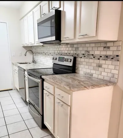 a kitchen with stainless steel appliances granite countertop a sink stove and cabinets