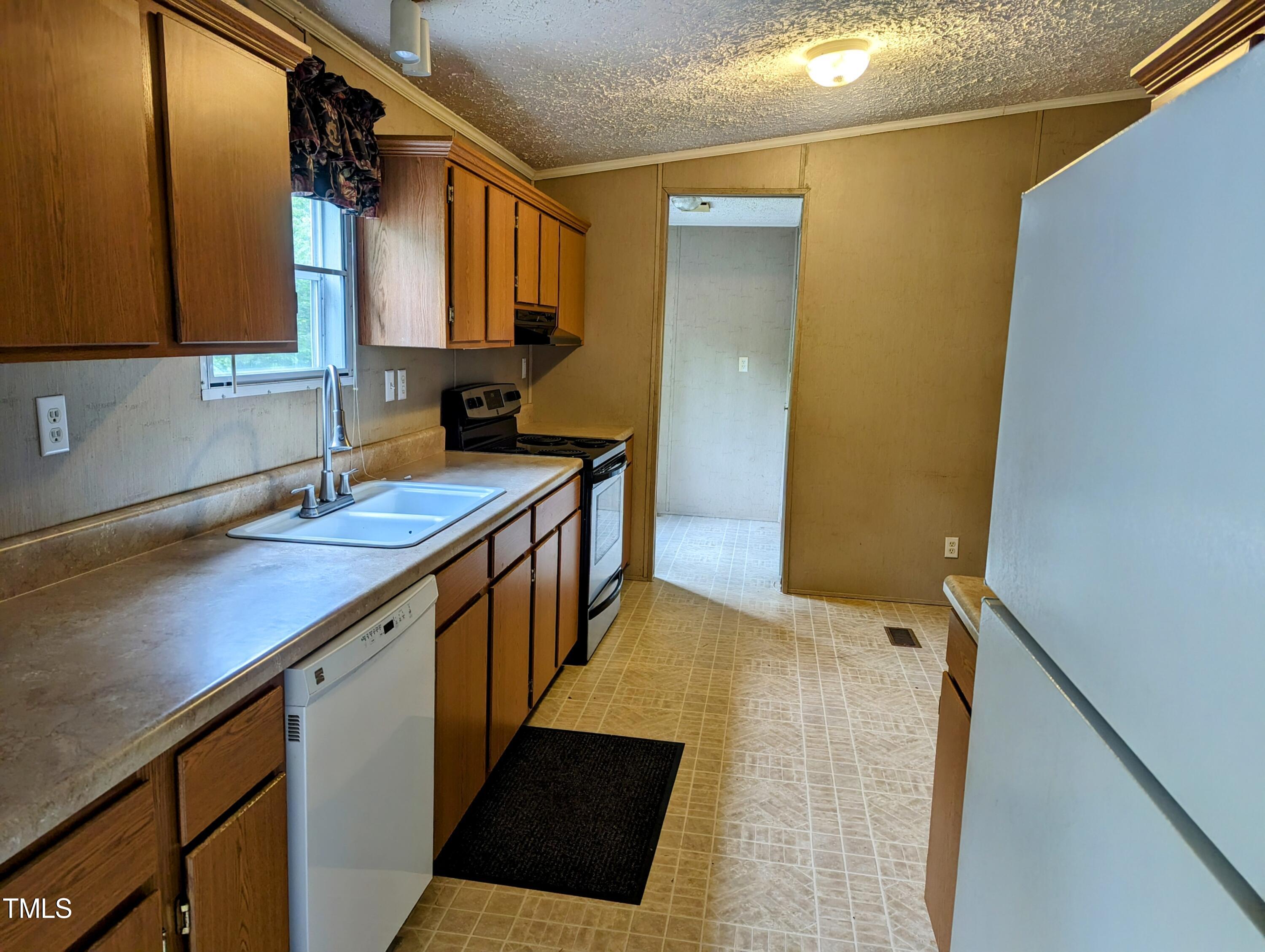 271 Buoy Drive Henderson, NC 27537 - Photo 8 of 21 a kitchen with a sink a stove top oven a refrigerator and a window
