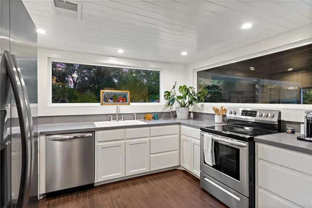 a kitchen with stainless steel appliances granite countertop a sink and stove top oven