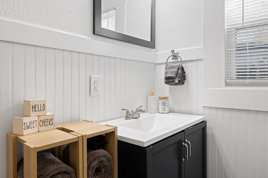 102 Ranchview Drive Johnson City, TX 78636 - Photo 22 of 37 Bathroom featuring vanity, a wainscoted wall, and a textured wall