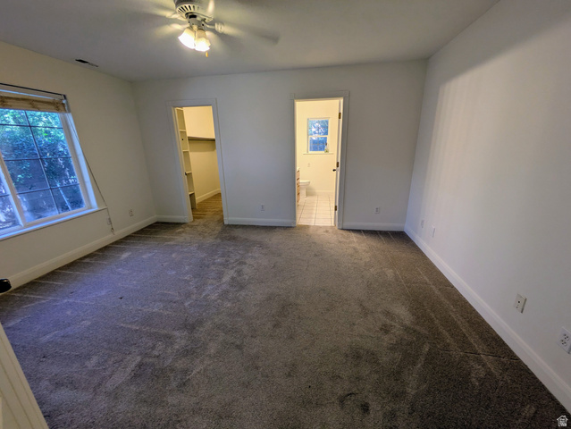 441 Main Street Hurricane, UT 84737 - Photo 17 of 29 Carpeted room featuring a ceiling fan with integrated lighting, a window with horizontal blinds, a walk-in closet with shelving, and an en-suite bathroom with tiled flooring
