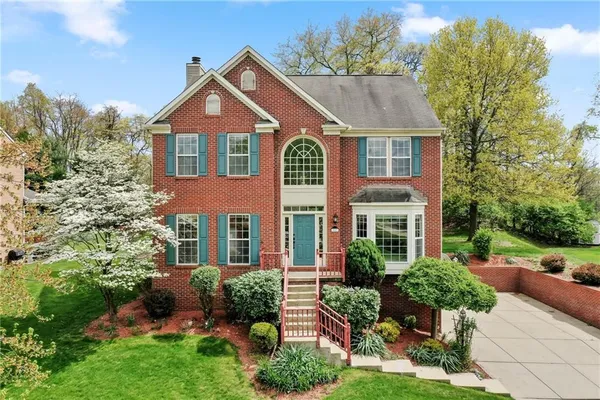 a front view of a house with a yard and potted plants