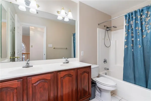 a bathroom with a sink a toilet a mirror a vanity and shower