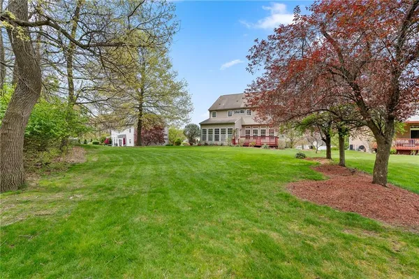 a view of a house with a big yard and large trees
