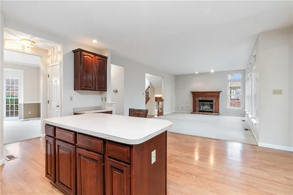 a view of kitchen island a sink dishwasher a fireplace with wooden floor