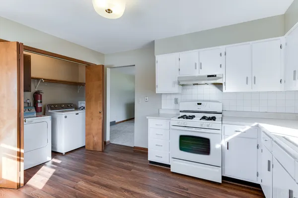 a kitchen with white cabinets and white appliances