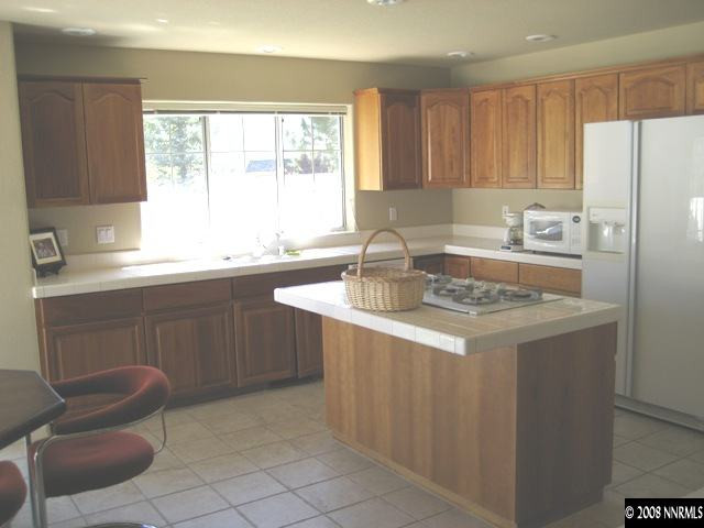 4723 Village Reno, NV 89519 - Photo 6 of 9 a kitchen with kitchen island granite countertop a sink stove and refrigerator