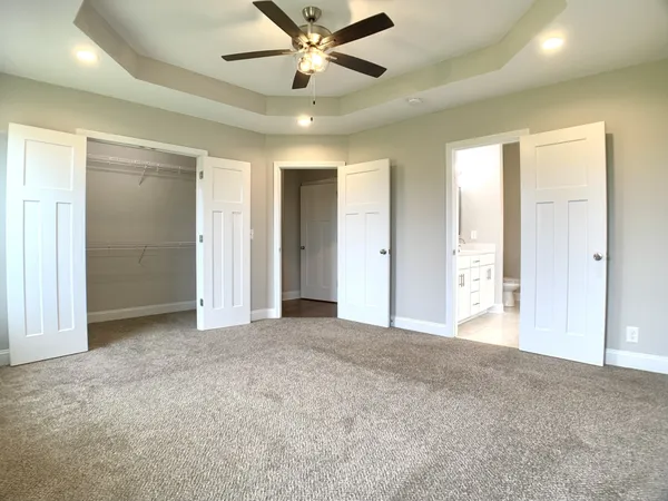 an empty room with closet and a ceiling fan