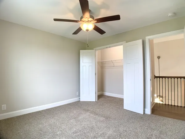 an empty room with fan and windows