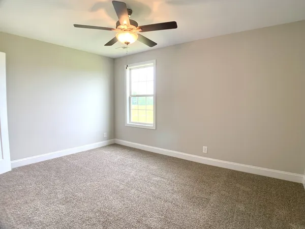 an empty room with a window and a fan