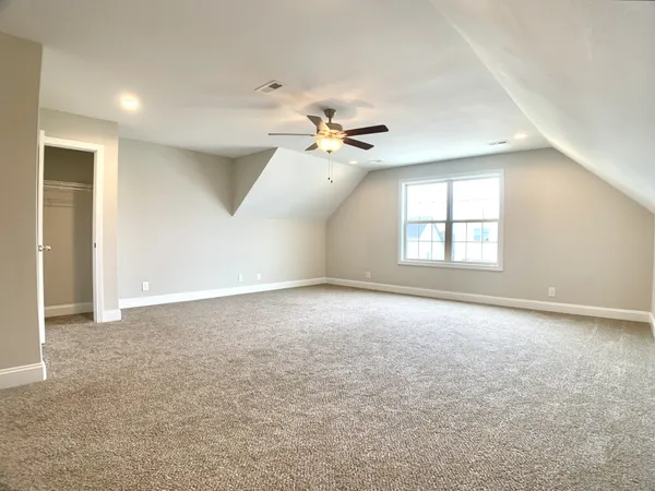 an empty room with windows and ceiling fan
