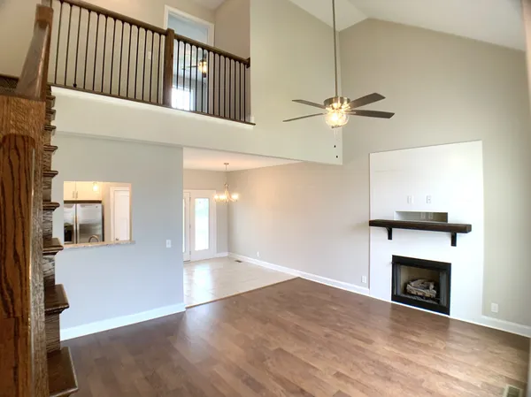 a view of a livingroom with a fireplace a chandelier and wooden floor