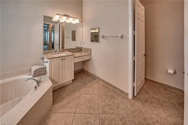 a bathroom with a bathtub sink and mirror