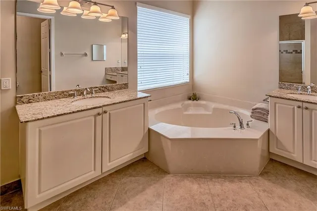 a spacious bathroom with a tub sink and mirror