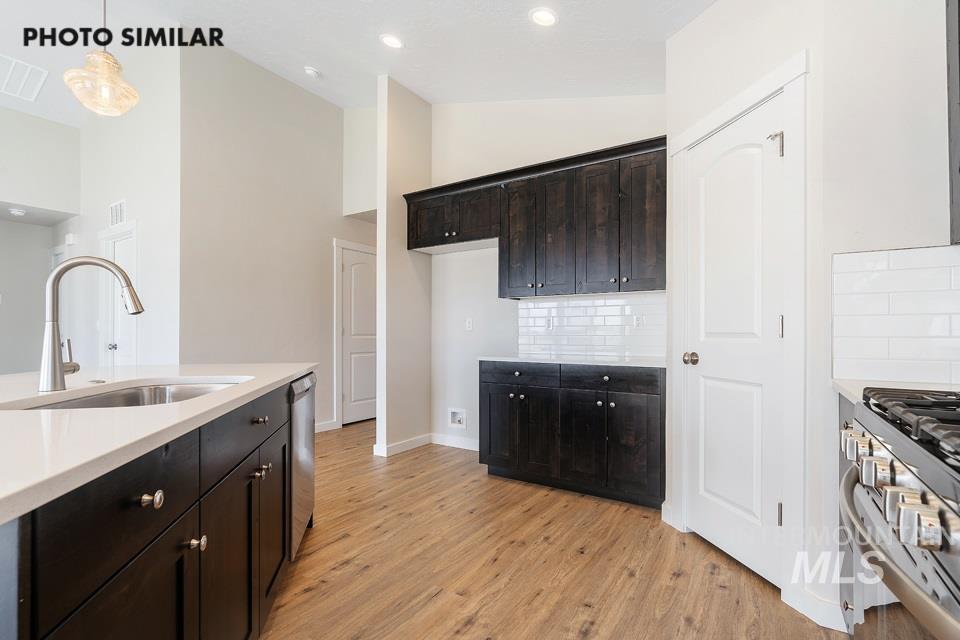 1708 Rapid Road Emmett, ID 83617 - Photo 12 of 33 Modern kitchen featuring dark wood cabinetry, light-toned countertops, and wood-finish flooring