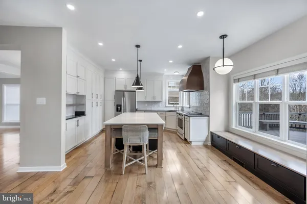 a bathroom with a granite countertop sink a toilet a mirror and a window