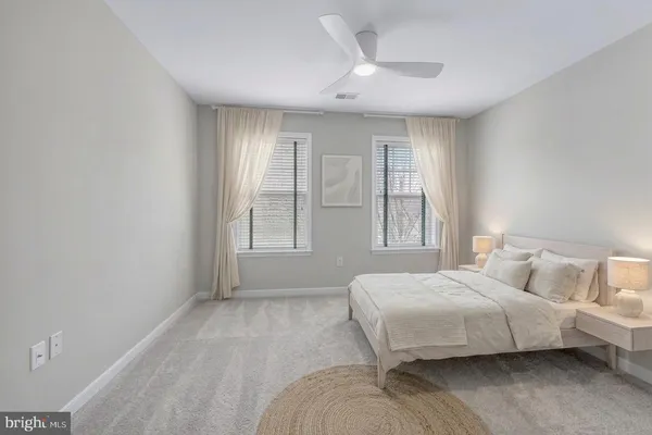 a view of patio with table and chairs under an umbrella with large trees