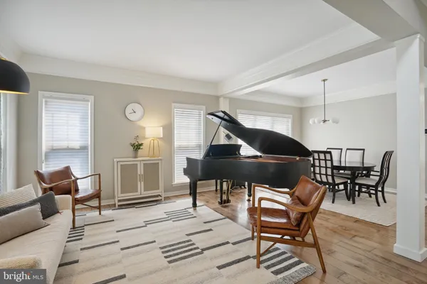 a view of a dining room and livingroom with furniture wooden floor a chandelier