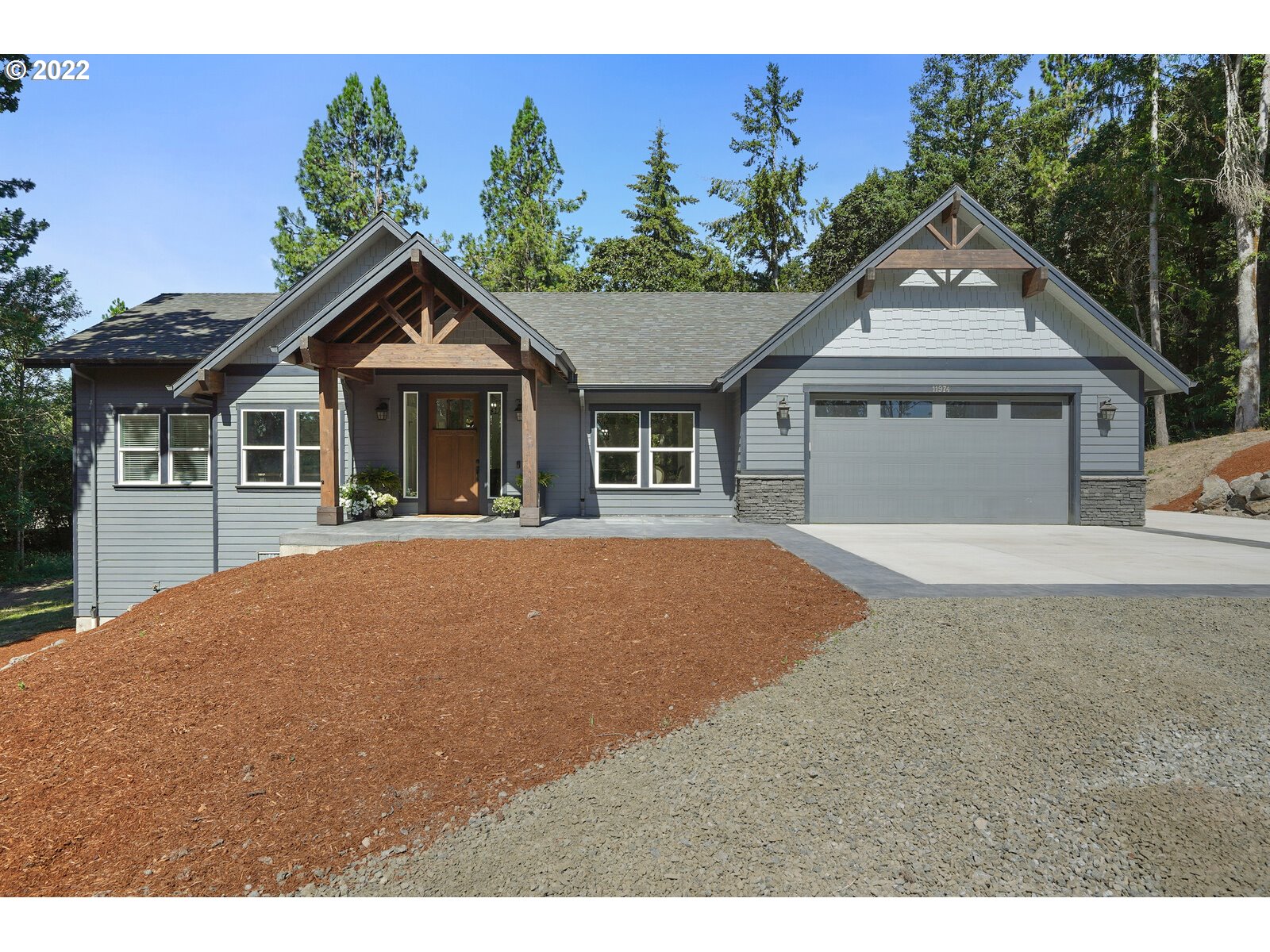 a front view of a house with a garden and yard