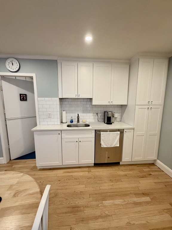 176 M Street, Unit 1 Boston, MA 02127 - Photo 2 of 11 a kitchen with granite countertop a white stove top oven and white cabinets