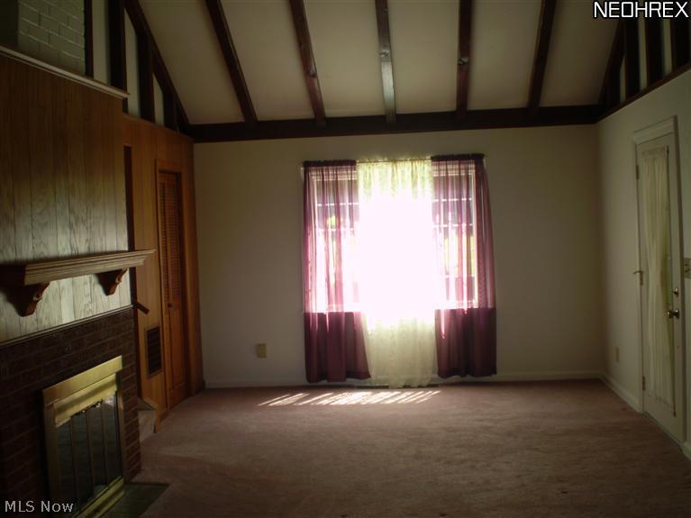 30509 Ridge Road Wickliffe, OH 44092 - Photo 16 of 24 The living room features a beamed vaulted ceiling and fireplace