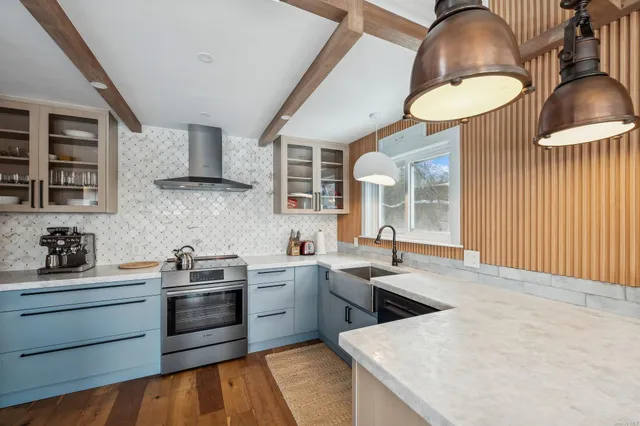 a kitchen with stainless steel appliances granite countertop a sink a stove and a wooden floors