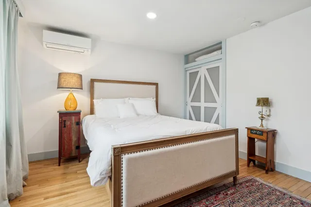 a bedroom with a bed and wooden floor