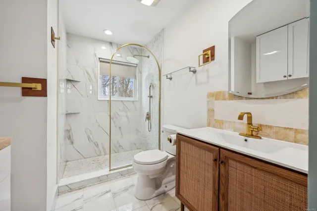 a bathroom with a sink a toilet and shower